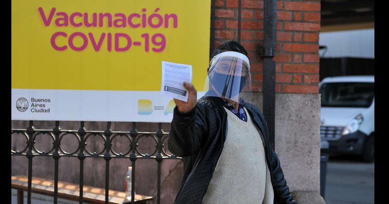 Un hombre muestra su carnet de vacunación tras aplicarse una dosis del suero contra el Covid