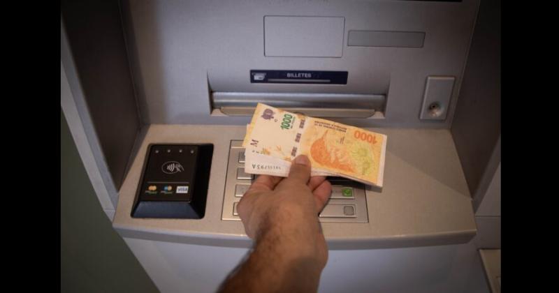 Un hombre retira dinero de una terminal de cajero